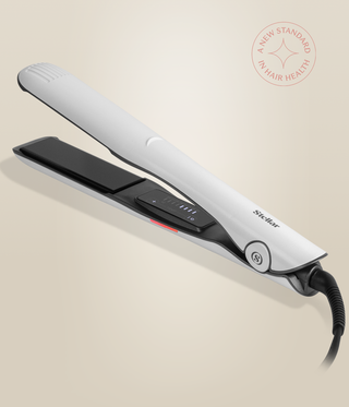 Pearl White Omnia Styler Plus lying open, showing its black plates and control panel.