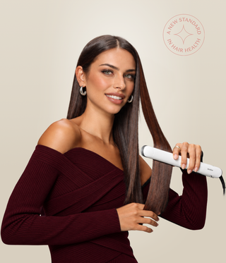 Woman styling her long brown hair with a white Stellar styler.