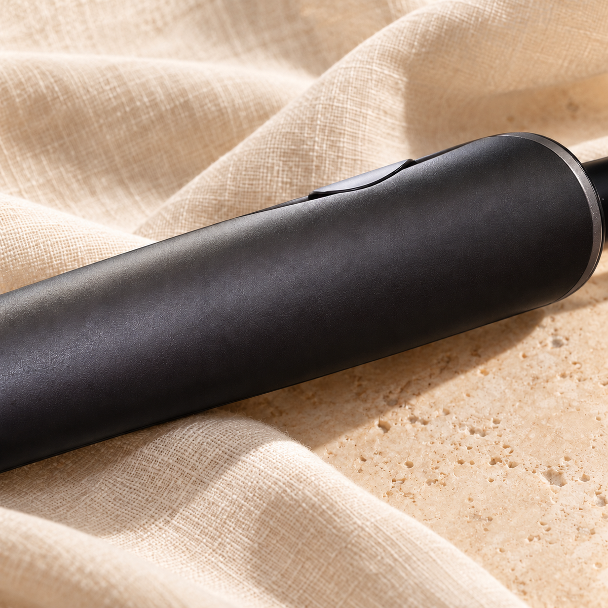 Illustrative black styler close-up on linen and stone
